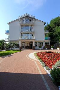 a large white building with a walkway in front at Hotel Stanger in Lovran