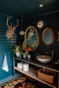 a bathroom with two mirrors and a sink at Woodcutters Forest Cottages in Knysna