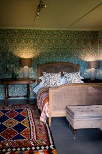 a bedroom with a bed and a couch and two lamps at Woodcutters Forest Cottages in Knysna
