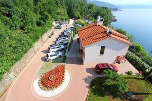 an aerial view of a building with cars parked next to the water at Hotel Stanger in Lovran