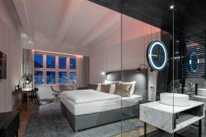 a bedroom with a bed and a bathroom with a sink at Pytloun Boutique Hotel Prague in Prague