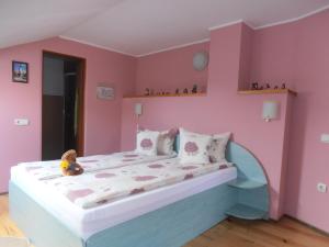 Un dormitorio rosa con una cama con un osito de peluche. en Casa Doma'r - Alina, en Sibiu