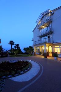 a large white building with a walkway in front of it at Hotel Stanger in Lovran