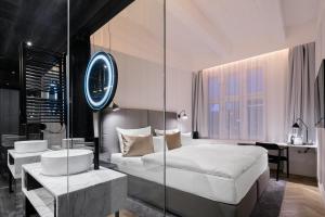 a bedroom with a bed and a desk and a mirror at Pytloun Boutique Hotel Prague in Prague