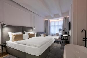a hotel room with a large bed and a desk at Pytloun Boutique Hotel Prague in Prague