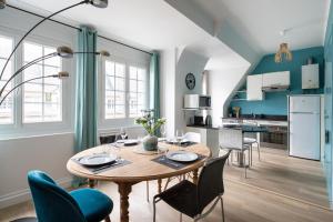 uma cozinha e sala de jantar com mesa e cadeiras em L'Anémone em Saint Malo
