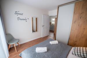a bedroom with a bed with two towels on it at Apartament Kasztanowy blisko centrum - Dream Apart in Szczyrk