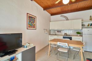 a kitchen with a table with chairs and a television at ACASADIGIULY in Ceriale