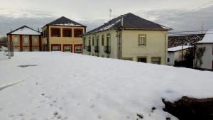 a pile of snow in front of some buildings at Casa Rosi. Cumbres borrascosas Brañuelas in Villagatón