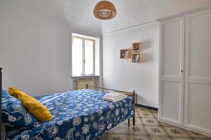 a bedroom with a bed with a blue blanket and a window at ACASADIGIULY in Ceriale