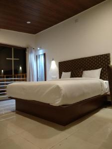 a bedroom with a large bed in a room at Olives Pleasant Stays in Ooty