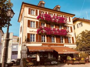 a building with flower boxes on the side of it at Café Tivoli in Châtel-Saint-Denis