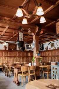 a restaurant with wooden tables and chairs and lights at Café Tivoli in Châtel-Saint-Denis