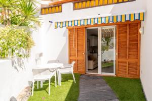 a patio with a table and chairs in a house at Parque Santiago III Official in Playa de las Americas