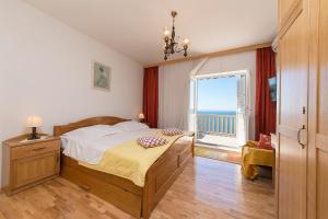 ein Schlafzimmer mit einem Bett mit Blick auf das Meer in der Unterkunft Apartments Joni in Brela