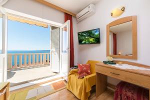 Zimmer mit einem Spiegel und einem Balkon mit Meerblick in der Unterkunft Apartments Joni in Brela