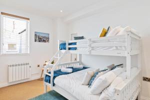 a bedroom with a white bunk bed with pillows at Seaview Heights - By My Getaways in Brighton & Hove