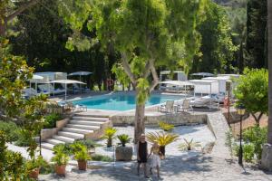 2 persone in piedi di fronte a una piscina di L’Hermitage Hotel & Spa a Orient