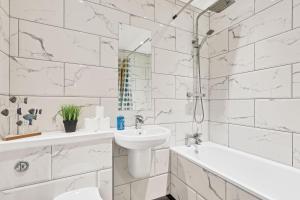 a white bathroom with a sink and a tub and a toilet at Seaview Heights - By My Getaways in Brighton & Hove