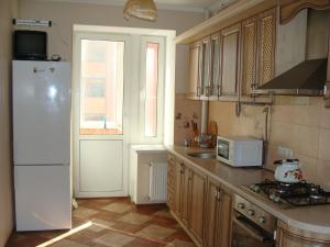 une cuisine avec un réfrigérateur blanc et une fenêtre dans l'établissement Apartment Irpen, à Irpin