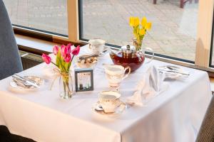 ein weißer Tisch mit Blumen und Tassen darauf in der Unterkunft Copthorne Hotel Merry Hill Dudley in Dudley