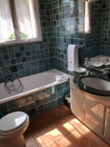 a bathroom with a tub and a toilet and a sink at Hotel Martinengo in Sainte-Maxime