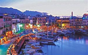 un gruppo di barche ormeggiate in un porto di notte di Kyrenia British Harbour Hotel a Kyrenia