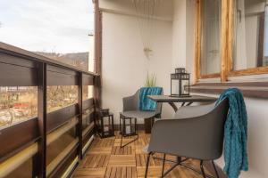 balcón con sillas, mesa y ventana en Apartament Lisowski CENTRUM, en Zakopane