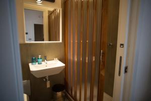 bagno con lavandino e doccia con specchio di B&B Kolymbetra a Agrigento