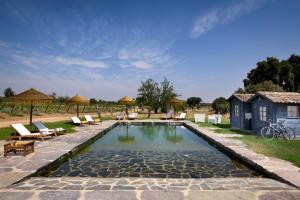 a swimming pool with chairs and a house at A Casa do Governador in Évora