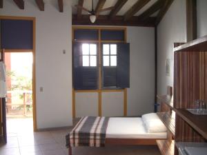 1 dormitorio con cama y ventana en Pousada Águas de Março, en São Jorge