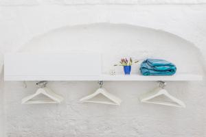 un estante blanco en una pared con perchas en Dimora Talenti Guest House, en Polignano a Mare