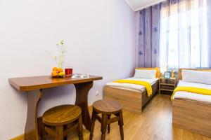 リヴィウにあるModern 2BR Apartment in Central Lvivのデスク、ベッド、テーブルが備わる客室です。