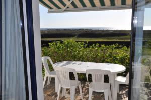 トレガンにあるMaison de vacances au bord de la plageのテーブルと椅子、海の景色を望むバルコニー