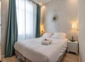 ein Schlafzimmer mit einem großen Bett, auf dem Handtücher liegen in der Unterkunft Résidence Montaigne - Luxurious - 350m Palais - LRA Cannes in Cannes + 48 Fotos