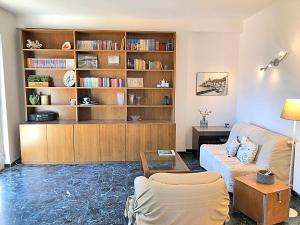 een woonkamer met een bank en een boekenplank bij Il Mare A Due Passi in Lerici