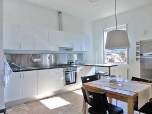 a kitchen with white cabinets and a table with chairs at Il Mare A Due Passi in Lerici