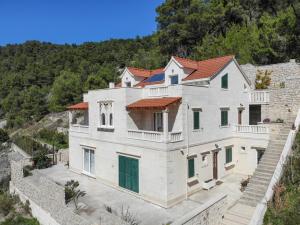 une grande maison blanche avec un toit rouge dans l'établissement Villa Mar 1 - Luxury apartments, à Pučišća