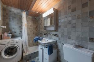 a bathroom with a washing machine and a sink at Ferienwohnung Sunnehöckli in Sattel