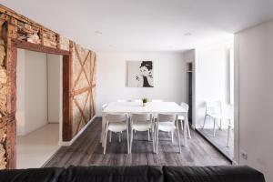 uma sala de jantar branca com uma mesa e cadeiras brancas em City Stays Cais do Sodre Apartments em Lisboa