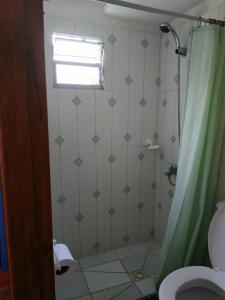 baño con ducha con cortina verde en Posada dos Palmas, en Barra de Valizas