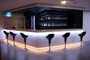 Eine Bar mit schwarzen Stühlen vor einem Tresen in der Unterkunft Rossio Hotel in Portalegre