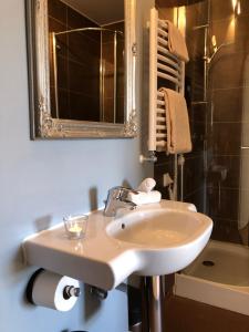 uma casa de banho com um lavatório, um espelho e uma banheira em Annas Hotell em Kristianstad
