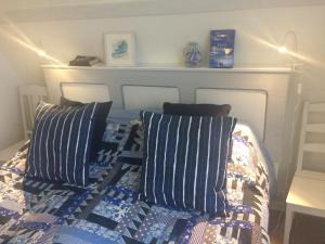 uma cama com cobertores e almofadas azuis e brancos em Steninge kuststation em Steninge