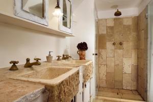 łazienka z 2 umywalkami i prysznicem w obiekcie B&B Trullo Barbagiullo w mieście Cisternino
