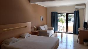 a hotel room with a bed and a chair and a window at Vilamar in Luz
