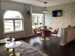 a living room with a table and chairs and a tv at Annas Hotell in Kristianstad