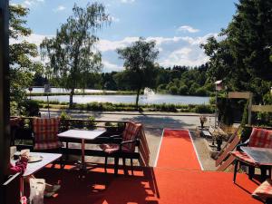 eine Terrasse mit einem Tisch und Stühlen sowie Seeblick in der Unterkunft Blackcoms Erika - Adults Only in Hahnenklee-Bockswiese