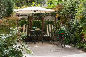 
a patio area with a table, chairs, and umbrella at Hotel Relais San Nicolò in Treviso
