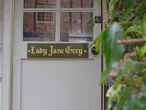 un cartel en la puerta principal de una casa en Lady Jane Grey, en Winchcombe